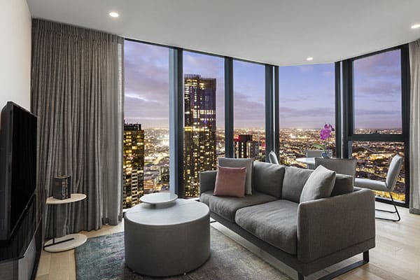 spacious living room with beautiful night view at the two bedroom superior suite of avani melbourne central residences